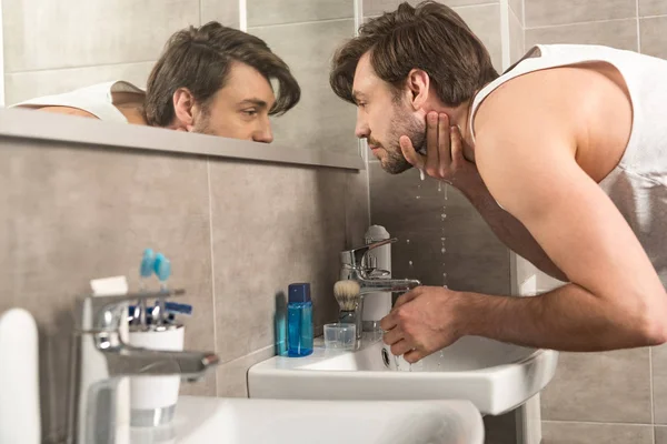 Banyoda Sabah Ayna Yakınında Yüz Yıkama Adam — Stok fotoğraf