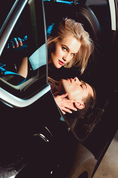 英俊的男人和美丽的年轻女子拥抱在车上 — 图库照片