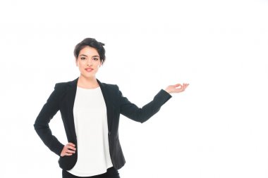 çekici karışık ırk iş kadını kalça el tutarak ve beyaz izole kamera gülümseyerek gesturing