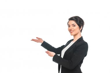 çekici karışık ırk iş kadını gesturing ve beyaz izole kamera gülümseyen