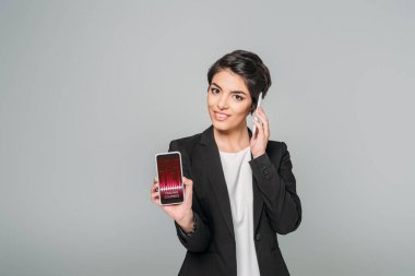 gri izole akıllı telefon konuşurken ekranda ticaret kursları uygulaması ile akıllı telefon gösteren güzel karma Yarış iş kadını