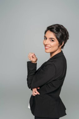 gri izole kamera poz verirken gülümseyen güzel karışık ırk iş kadını