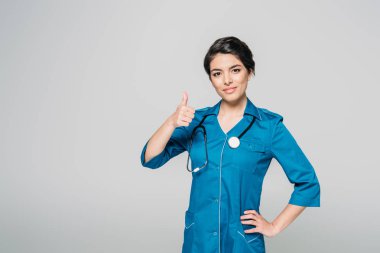 gri izole kalça eliyle kamera poz verirken oldukça karışık yarış doktoru başparmak gösteren