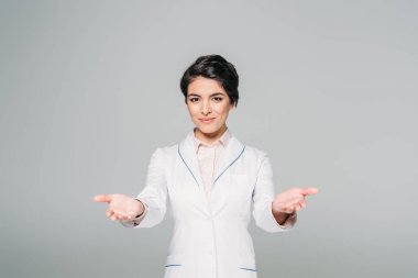 gülümseyen karışık yarış doktoru gri izole kamera hoş geldiniz jesti gösteren