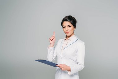 gri izole pano tutarken fikir işareti gösteren oldukça karışık yarış doktoru