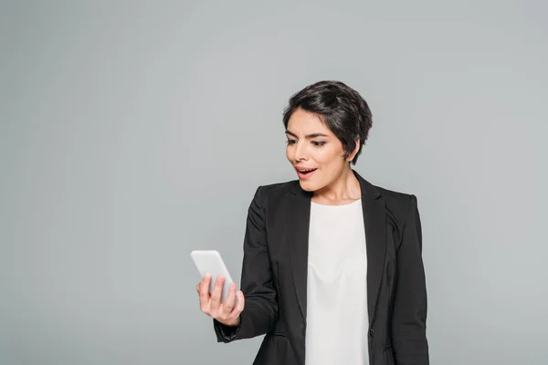 Verrast Gemengde Race Zakenvrouw Kijken Naar Smartphone Geïsoleerd Grijs — Stockfoto