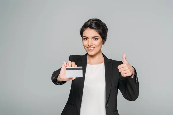 Lächelnde Gemischte Geschäftsfrau Mit Kreditkarte Und Erhobenem Daumen Auf Grau — Stockfoto