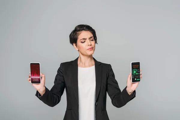 Atraente Mestiço Cético Empresária Segurando Smartphones Com Cursos Negociação Aplicativos — Fotografia de Stock