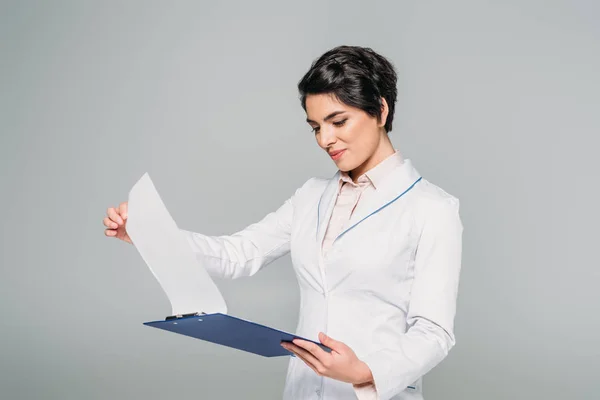 Attentive Mixed Race Doctor Looking Clipboard Papers Isolated Grey — Stock Photo, Image