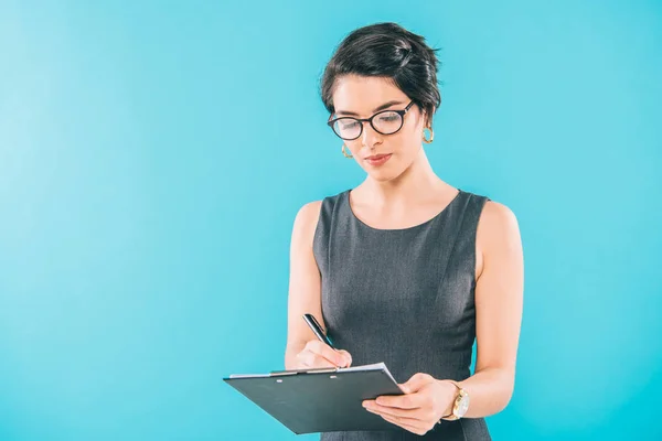 Attentive Mixed Race Businesswoman Glasses Writing Clipboard Isolated Blue — Stock Photo, Image