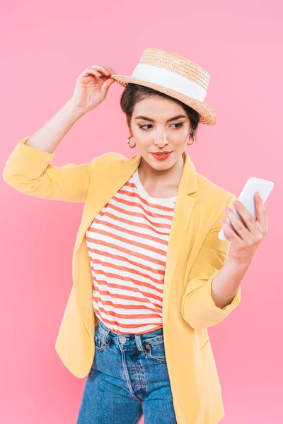 Pretty Mixed Race Woman Touching Straw Hat While Using Smartphone — Stock Photo, Image