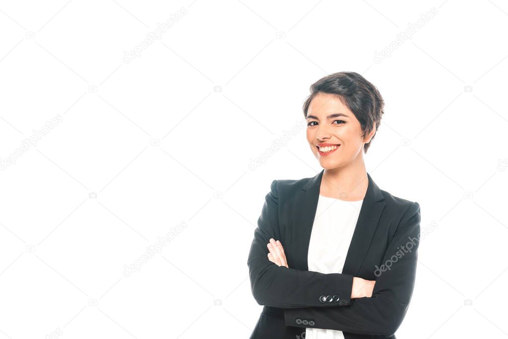 cheerful mixed race businesswoman standing with crossed arms and smiling at camera isolated on white