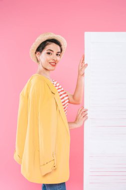 pembe arka planda katlanır ekranın yanında duran güzel karışık ırk kadın