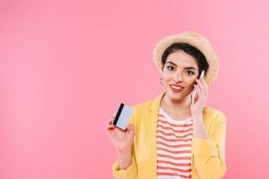 akıllı telefon konuşuyor ve pembe izole kredi kartı tutan çekici karışık ırk kadın