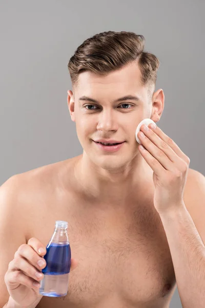 Smiling Naked Young Man Holding Lotion Bottle Wiping Face Cotton — Stock Photo, Image