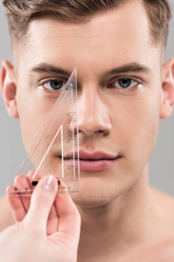 gri üzerinde izole cetvel ile yüz ölçme plastik cerrah kırpılmış görünümü