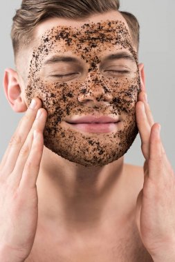 gri izole kapalı gözleri ile scrub uygulayan yakışıklı genç adam