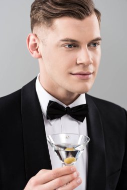 gri izole kokteyl cam tutan papyon ile resmi giyim gülümseyen genç adam