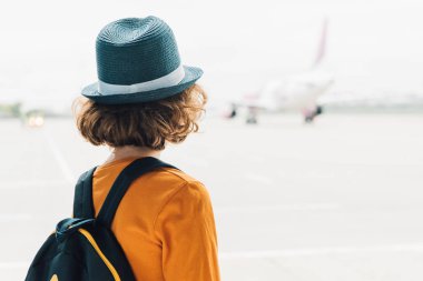 Arka görünüm ile preteen çocuk içinde sırt çantası ile Havaalanı seyir içinde pencere