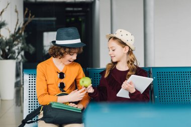 sevimli preteen çocuklar oturma içinde bekleyen salon ve paylaşım elma