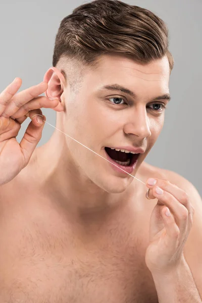 Schöner Junger Mann Reinigt Zähne Mit Zahnseide Isoliert Auf Grau — Stockfoto