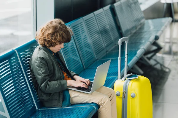 Side View Boy Typing Laptop Sitting Blue Seat Yellow Suitcase — Stock Photo, Image