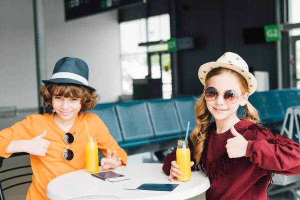 Preteen Kids Sitting Table Orange Juice Departure Lounge Showing Thumbs — Stock Photo, Image