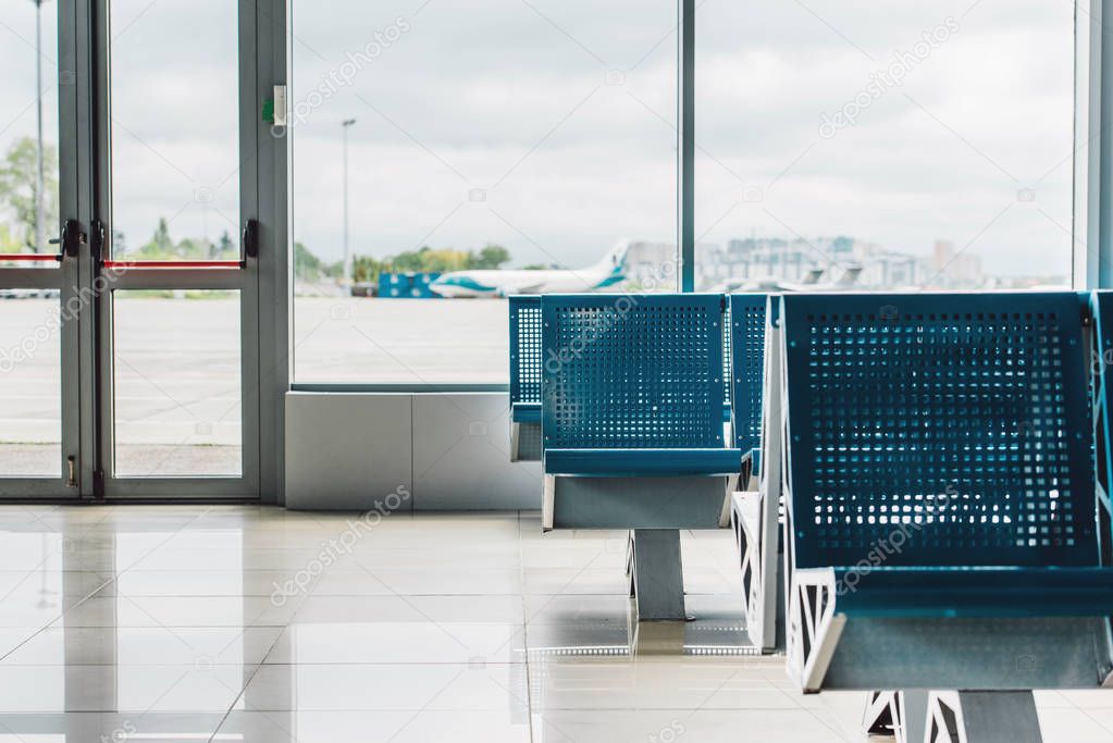  waiting hall in airport with blue seats and window