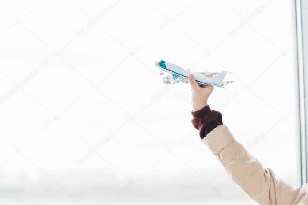 Cropped view of preteen kid holding toy plane with copy space