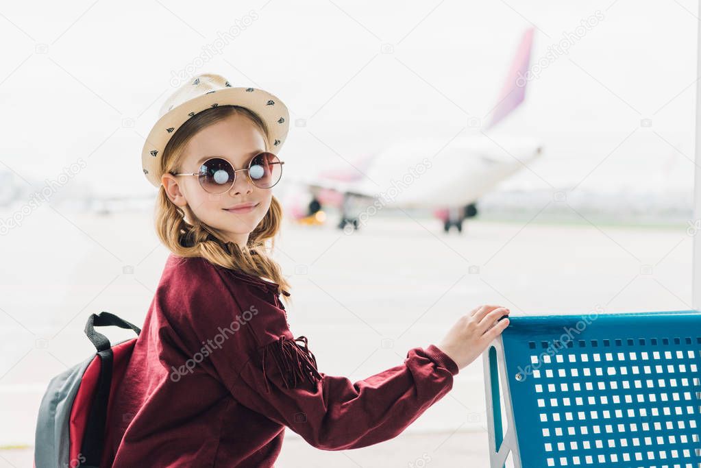 adorable preteen kid with backpack in sunglasses in airport
