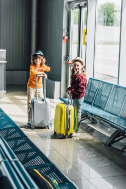 bekleyen salonda bavullar ile sevimli preteen çocuklar kamera bakıyor