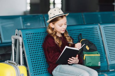 preteen çocuk oturma içinde bekleme salonu ve yazma içinde Notebook