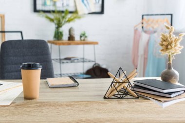 Kağıt fincan sabit yakın, notebooklar ve vazo ile catkins 