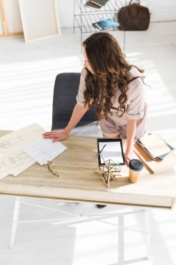 Tablo yakın ayakta iken kıvırcık kız moda skeçler bakarak tepegöz görünümü 