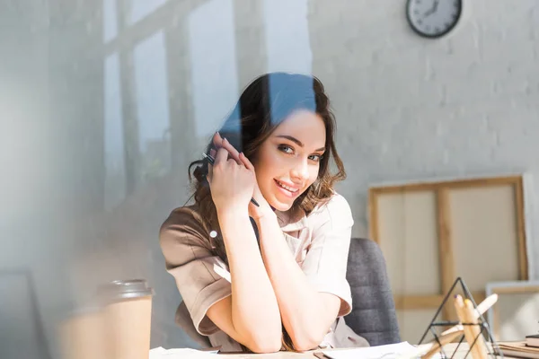 Chica Sonriente Mirando Cámara Cerca Taza Papel Mesa — Foto de Stock