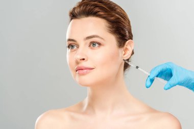 gri izole güzel ve çıplak kadın yakınında şırınga tutan kozmetolojist kırpılmış görünümü 