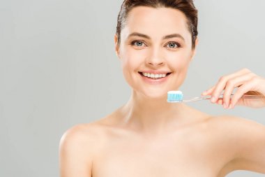 gri izole diş macunu ile diş fırçası tutarken neşeli çıplak kadın gülümseyen 