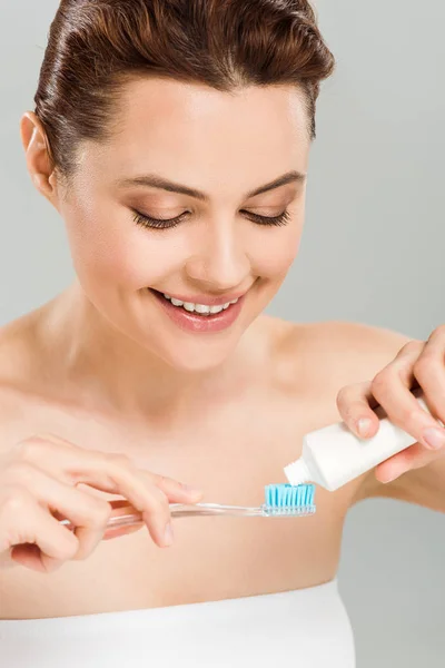 Весела Жінка Тримає Зубну Пасту Біля Зубної Щітки Ізольовано Сірому — стокове фото