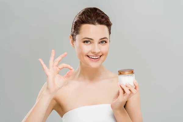 Cheerful Woman Showing Sign Holding Face Cream Isolated Grey — Stock Photo, Image