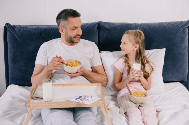 sevimli kızı ile yakışıklı adam babalar gününde yatakta birlikte kahvaltı yapıyor