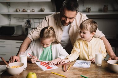 mutlu baba kahvaltı servis ile mutfak masasında otururken babalar gün tebrik kartları çizim sevimli çocuklar yanında duran