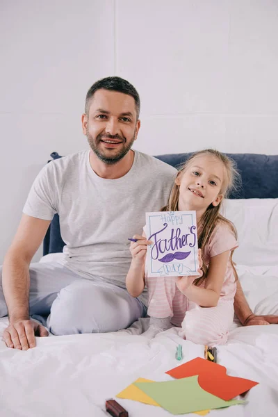 Happy Dad Sitting Bedding Adorable Daughter Holding Fathers Day Greeting — Stock Photo, Image