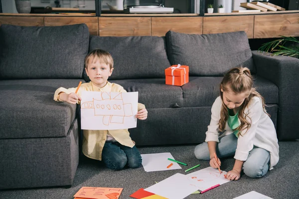 Cute Boy Showing Drawing While Sitting Floor Sofa Together Sister — Stock Photo, Image