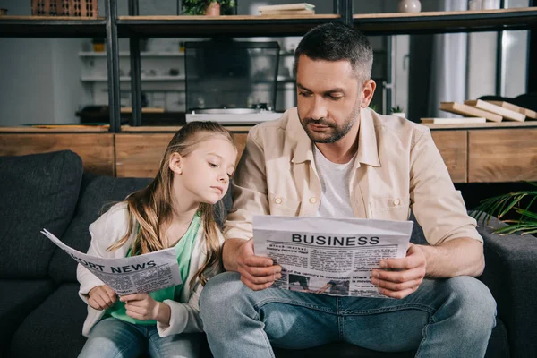 Father Daughter Reading Sport News Business Newspapers While Sitting Sofa — Stock Photo, Image