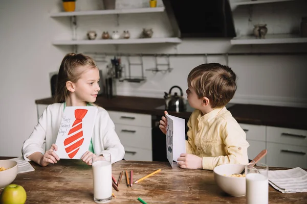 Adorable Kids Holding Fathers Day Greeting Cards While Sitting Kitchen — Stock Photo, Image