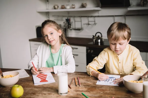 Liebenswertes Geschwisterpaar Sitzt Küchentisch Mit Serviertem Frühstück Und Zeichnet Grußkarten — Stockfoto