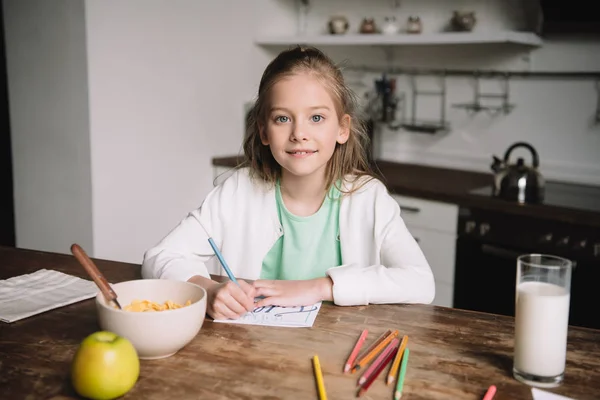 Lindo Niño Sonriendo Cámara Mientras Está Sentado Mesa Cocina Dibujar —  Fotos de Stock