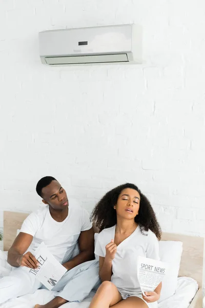 Hombre Afroamericano Mirando Mujer Sudorosa Habitación Con Aire Acondicionado —  Fotos de Stock