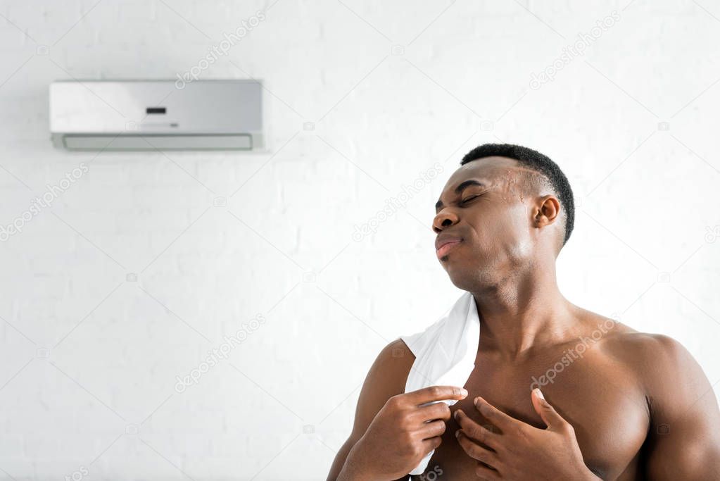 african american man standing in room with air conditioner