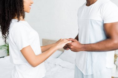 cropped view of african american woman holding hands with boyfriend clipart